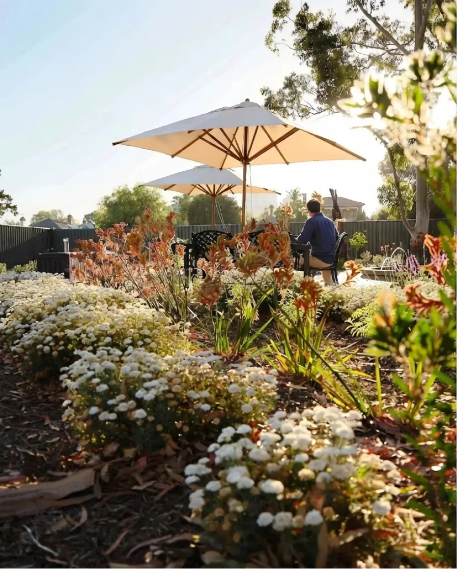 Residents relaxing under umbrellas in the landscaped Ardmillan gardens